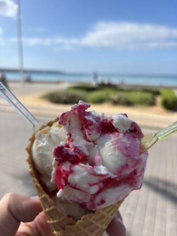 Eis in der Waffel mit Himbeersoße vor dem Strand