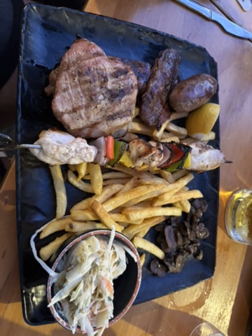 Grillplatte mit Steak, Spießen, Pommes und Krautsalat