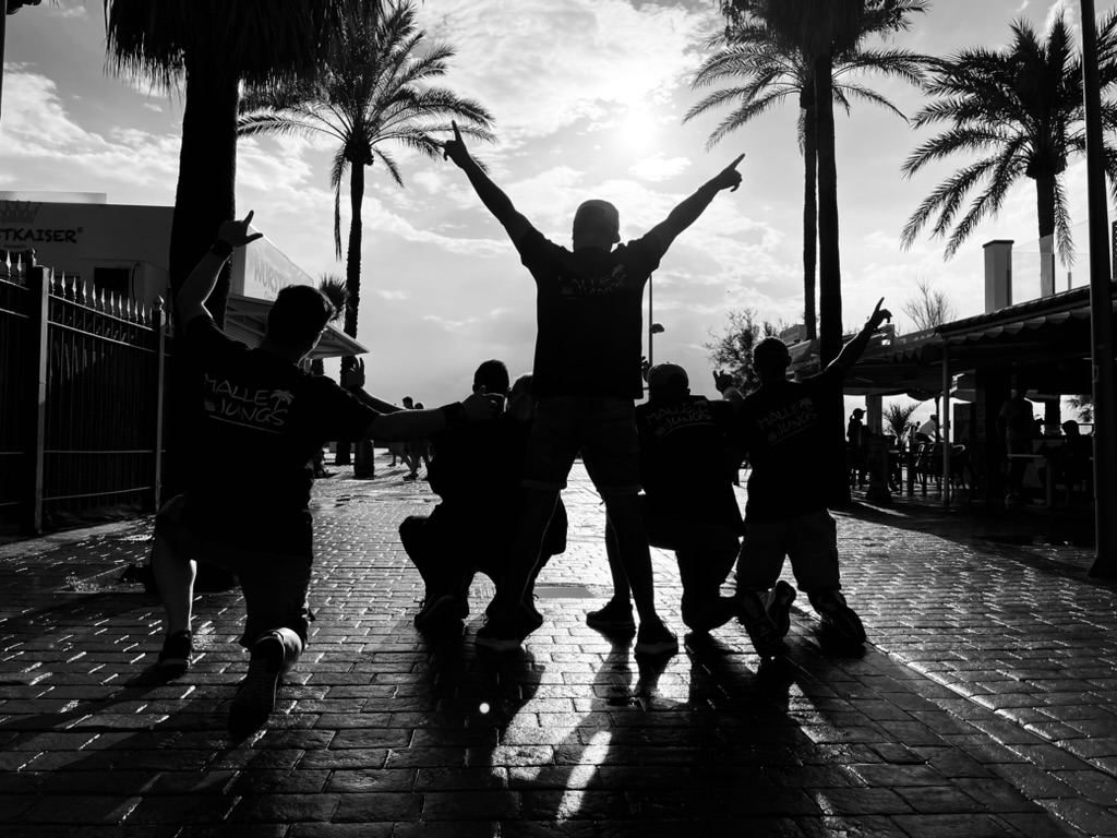 Die Malle Jungs in Silhouette unter Palmen an der Playa de Palma